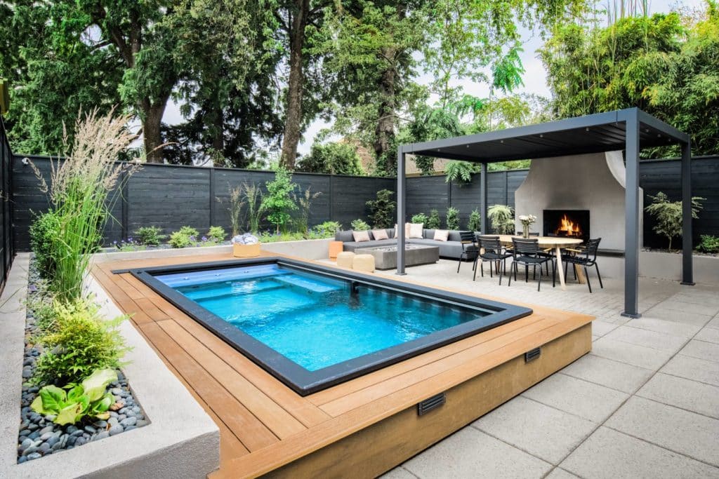 Backyard designed by Yardzen with plunge pool, fireplace, lounge area, and outdoor dining area covered by pergola