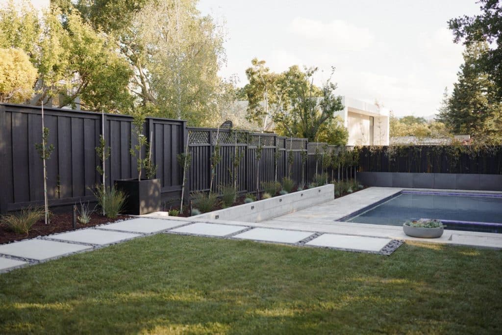 Black fence and plants near swimming pool
