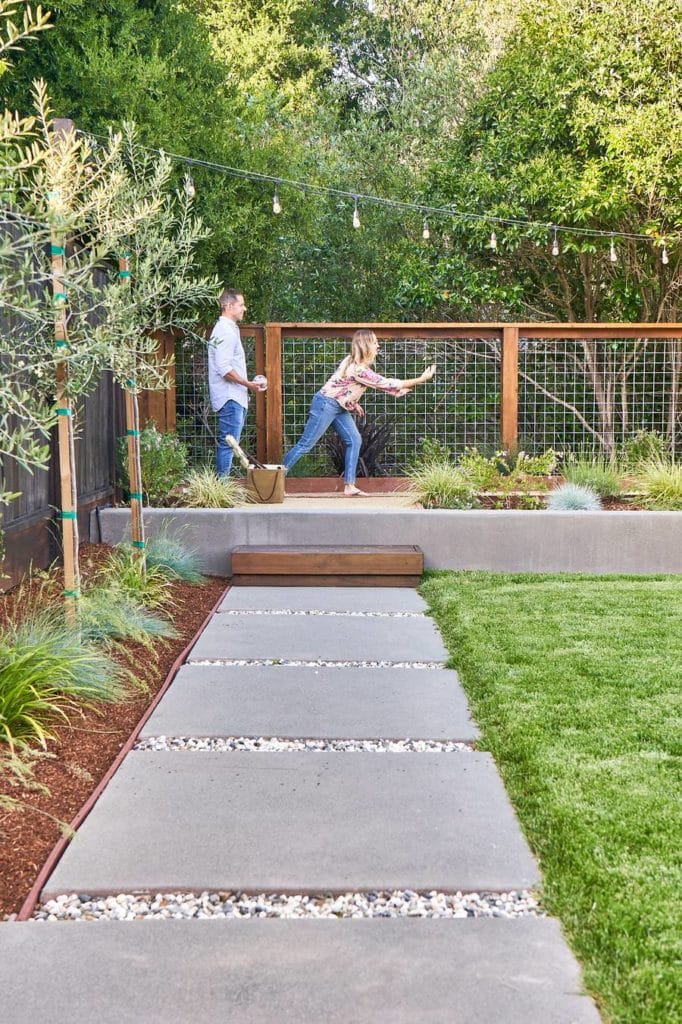 Man and woman playing bocce ball in their backyard