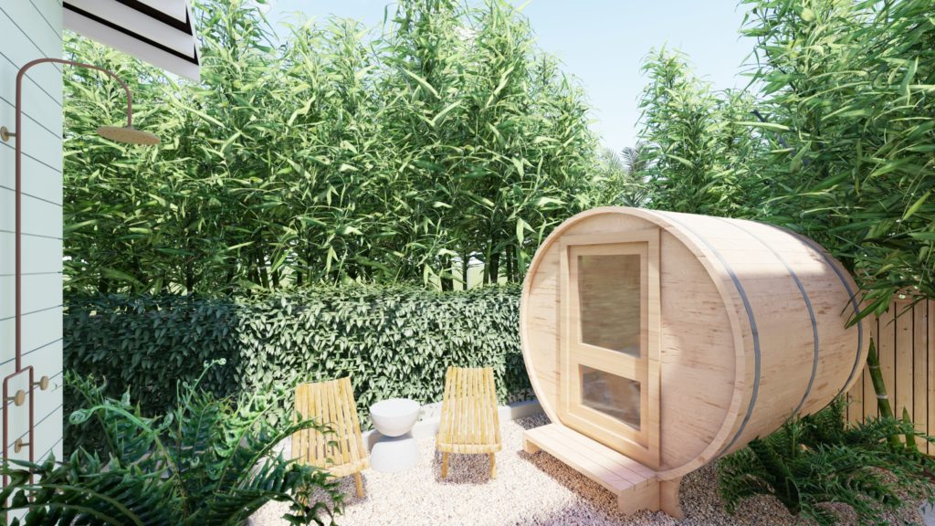 A corner of backyard with barrel sauna and outdoor chairs on gravel, surrounded by tall-growing bamboo for privacy.