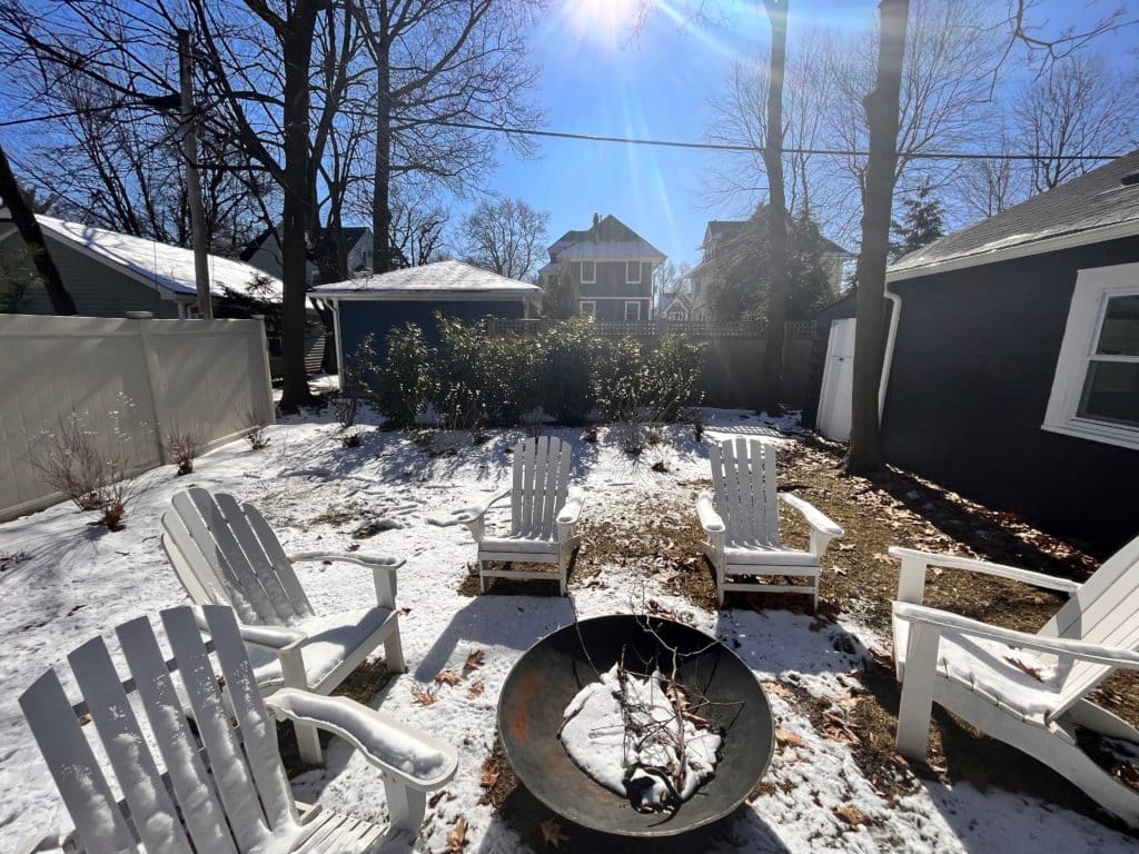 Snow covered backyard with fire pit